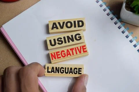 Avoid using negative language on stacked wooden cubes on the table. Stock Photos