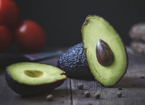 Avokado on the table, on the background tomatoes Stock Photos