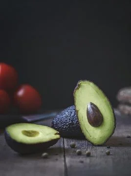 Avokado on the table, on the background tomatoes Stock Photos