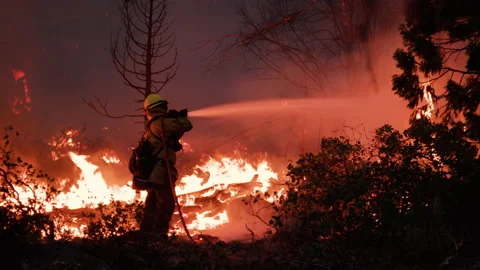 Awesome Close Up POV of lone Firefighter applying water to Large Fire Stock Footage 201816735