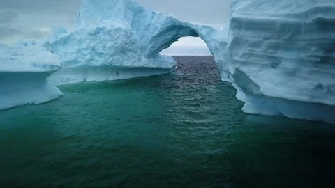 Awesome ice bridge, Arctic global warming, iceberg flying through arch Stock Footage 122164489