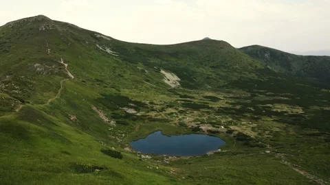 Awesome mountain valley and a small lake. Nesamovyte lake in the Carpathians. Video stock 169885864