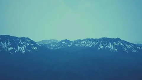Awesome top view through clouds to high snowy mountains Stock Illustration