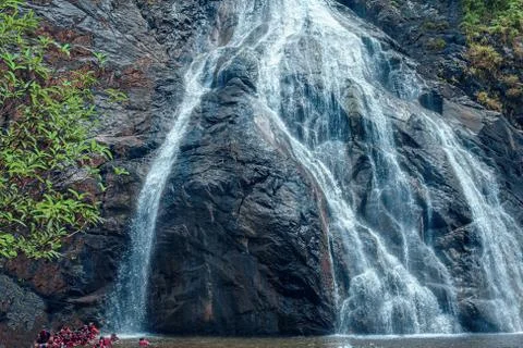 Awesome view of waterfall passing through a mountain big rock near by water r Stock Photos