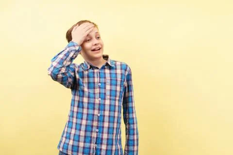 Awkward embarrassed boy covers forehead with hand Stock Photos