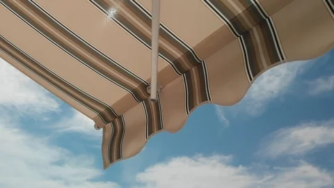 Awning opening against blue sky on sunny day Stock Footage