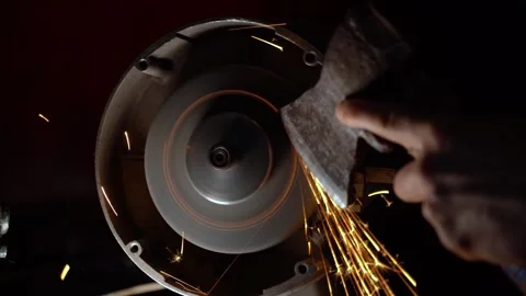 The ax is sharpened with an abrasive wheel on a grinder in the dark close-up Stock Footage 240271118
