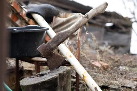 An axe in a stump on the farmyard Stock Photos