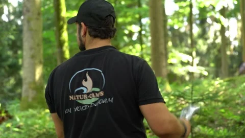 Axe throwing instructor demonstrating proper grip and release technique during Stock Footage 330970457