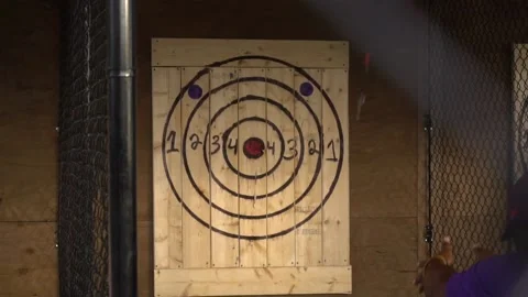 Axe throwing target cages with two people throwing axes in slow motion Stock Footage 146388471