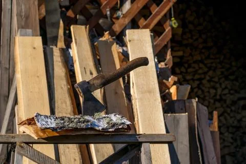 Axe thrust in a birch bark on a log near the woodpile. Stock Photos