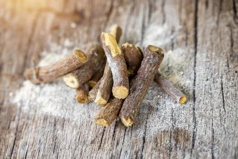 Ayurvedic mulethi or liquorice root stick or jeshthamadh powder on wooden b.. Fotos Stock