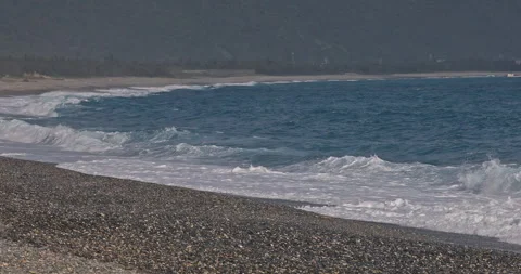 The azure Pacific Ocean washes against the gravel beaches of Qixingtan Beac.. 库存影片 332500449