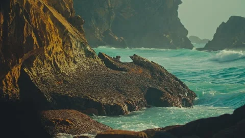 Azure sea waves roll over the rocky coast on a bright sunny summer day. 動画素材 329695370