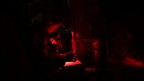 B-52 Stratofortress flight engineer reviewing notes under night vision lighting Stock Footage 292778163
