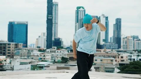 B-boy dancer practicing street dancing at rooftop with city view. Hiphop. Stock Photos