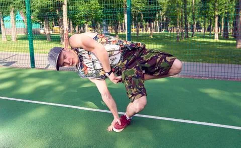 B-boy doing stunt trick on basketball field with ball Stock Photos