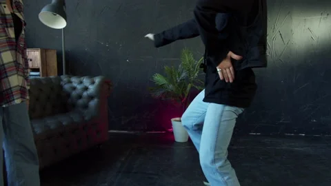 B-boy shows modern moves to a girl in a dance studio with black walls and floor Stock Footage 160861732