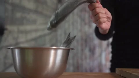 B roll sequence of seabream fish going from bowl to chopping board Stock Footage 131046338