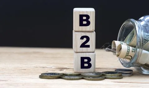B2B - abbreviation on cubes on the background of a capacity with money Stock Photos