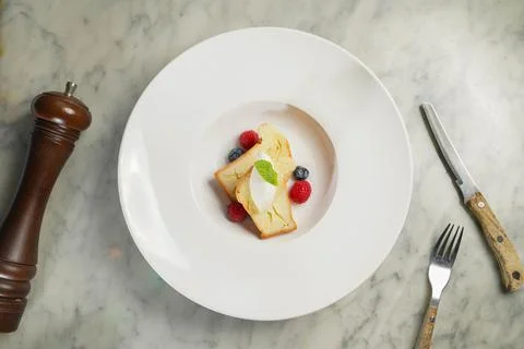 Baba Au Rhum with raspberry, blueberry, cream and bread served in dish isol.. Stock Photos