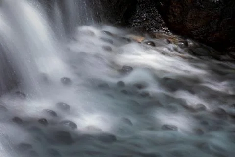 The babbling brook flows over the rocks Stock Photos