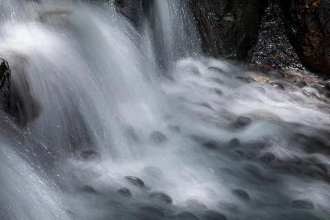 The babbling brook flows over the rocks Stock Photos