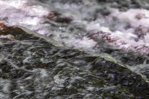 The babbling brook flows over the rocks Stock Photos