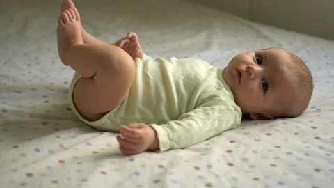 Babe on a back on a bed moving her hands and legs Stock Footage 106090692