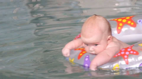 Baby 3 months learn to swim in the pool, on the rubber ring Stock Footage 45971753