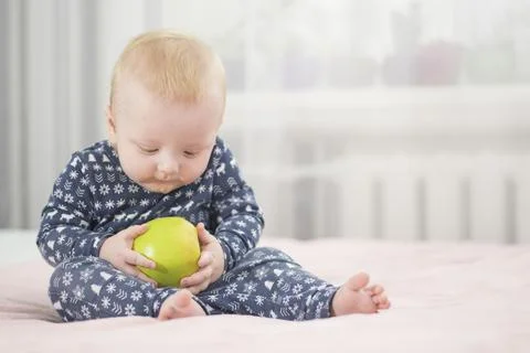 Baby with an apple Stock Photos