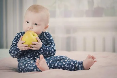 Baby with an apple Stock Photos