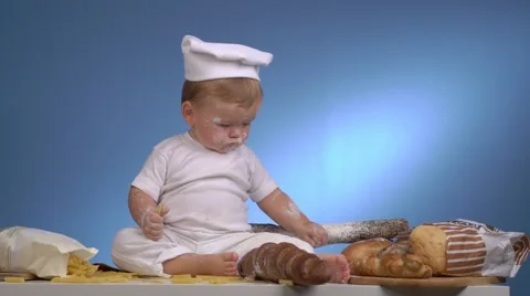 Baby baker in hat playing with bread Stock-Footage 68969602