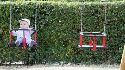 Baby balancing in a swing next to another balancing rocking chair Video stock 12300538