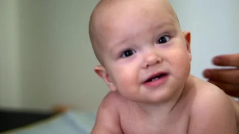 A baby with a bald head is looking at the camera 스톡 동영상 319416546