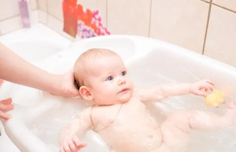 Baby bathing in the bath Stock Photos
