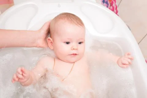 Baby bathing in the bath Stock Photos