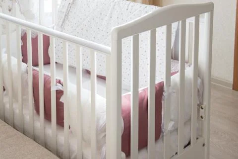 Baby bed crib with white and Burgundy color pillows with laces Stock Photos
