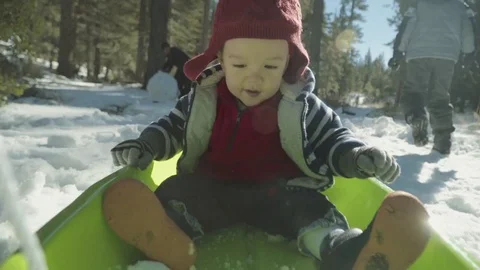 Baby being pulled on a sled Stock Footage 71070458