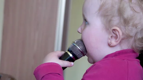 Baby bites the microphone Stock Footage 156036644