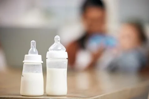 Baby bottle, milk and parent with child for healthcare, wellness or home love Stock Photos