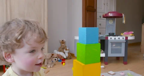 Baby boy building tower of square blocks slow motion 60fps Video stock 57651944