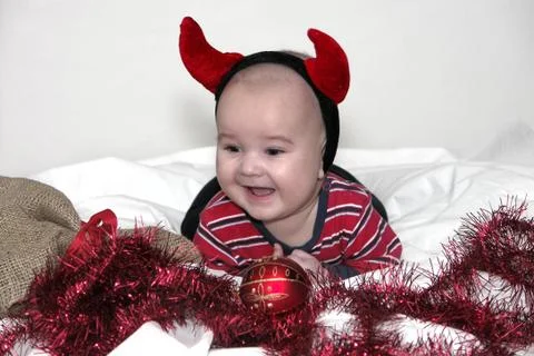 Baby boy in change behind devil and Christmas Foto stock