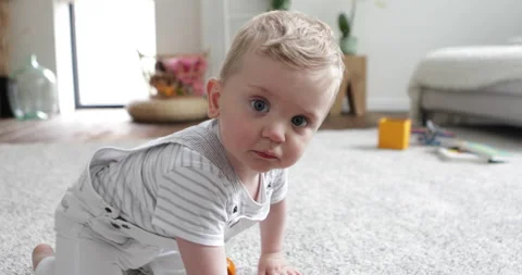 Baby boy crawling slow motion looking in and touching camera Stock Footage 154369867