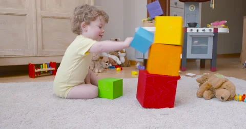 Baby boy destroying  tower of square blocks slow motion 60fps Stock-Footage 57652178