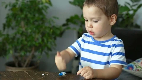 Baby boy doing funny faces while playing with dough Stock Footage 84096435