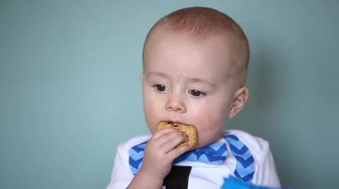 Baby boy eats a chocolate chip cookie Stock Footage 61925432