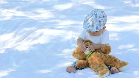 Baby boy exploring teddy bear toy nose Stock Footage 12300177