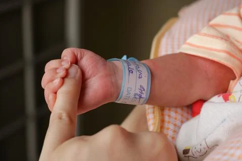Baby boy holding finger of his mother, Infant holding his mother's hand Stock Photos