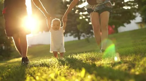 Baby boy learning to walk. Taken against the sun Stock Footage